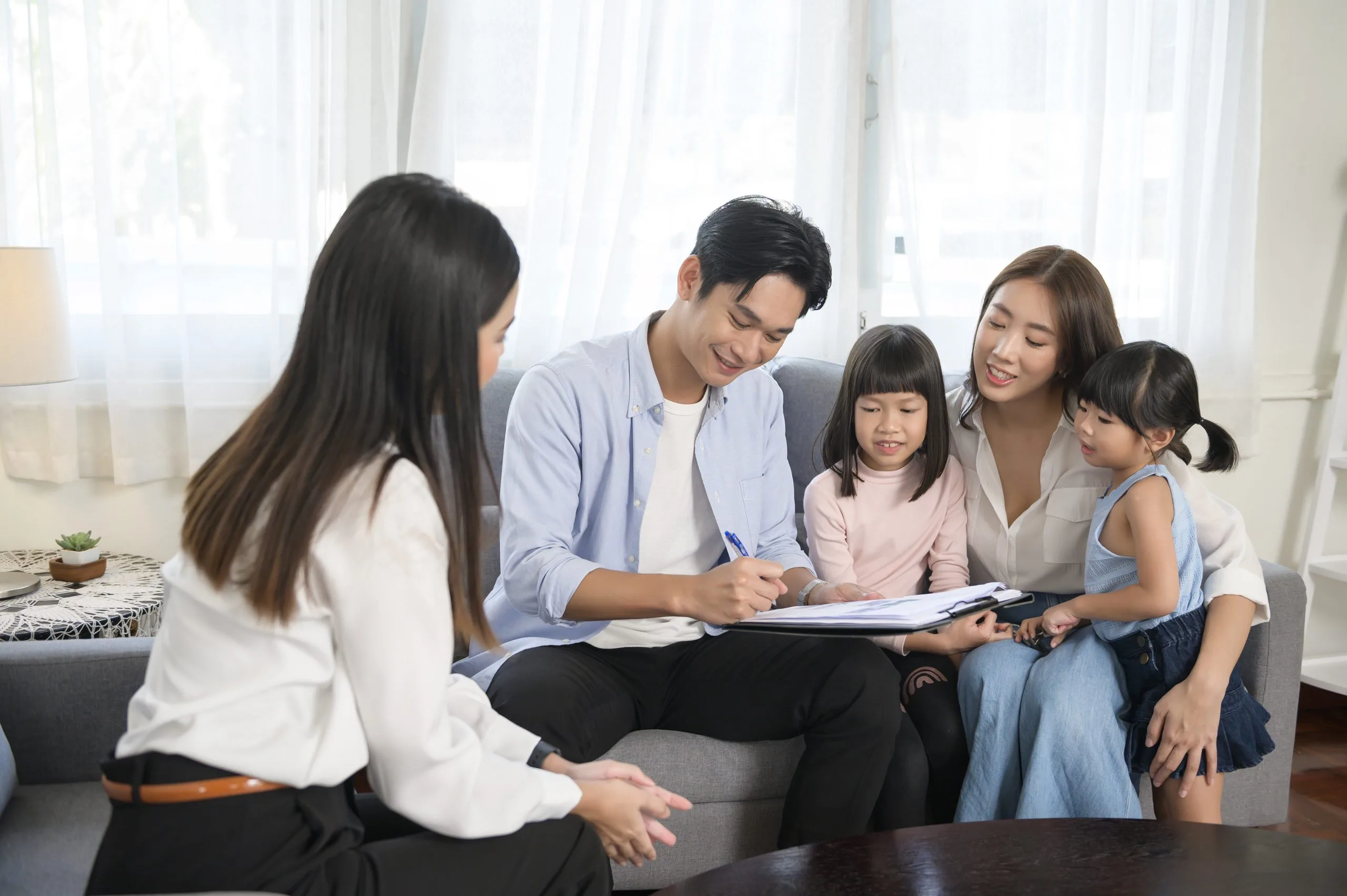Family meeting with female insurance consultant offering promotions
